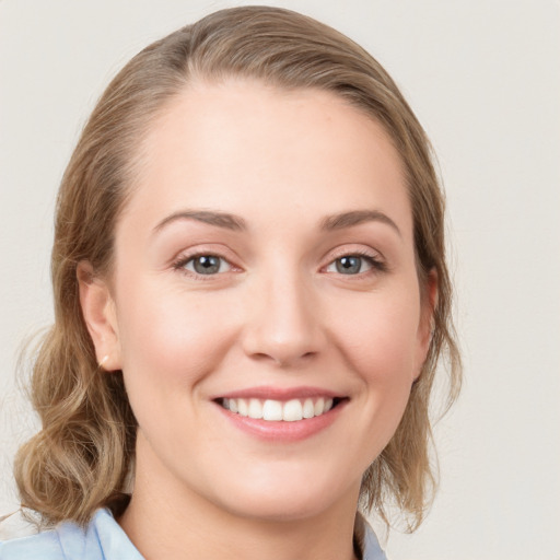 Joyful white young-adult female with medium  brown hair and blue eyes