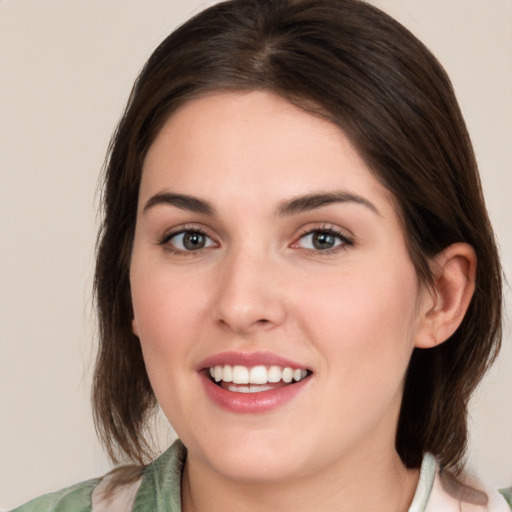 Joyful white young-adult female with medium  brown hair and green eyes