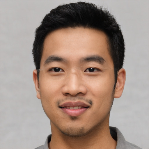 Joyful asian young-adult male with short  black hair and brown eyes