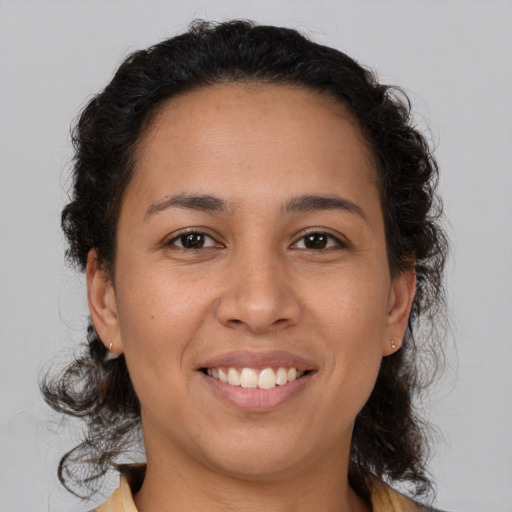 Joyful latino young-adult female with medium  brown hair and brown eyes