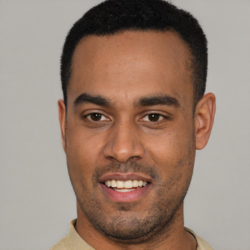 Joyful black young-adult male with short  black hair and brown eyes