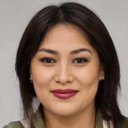 Joyful latino young-adult female with long  brown hair and brown eyes