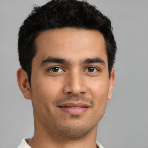 Joyful latino young-adult male with short  brown hair and brown eyes