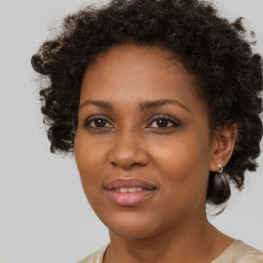Joyful black young-adult female with medium  brown hair and brown eyes