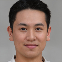 Joyful asian young-adult male with short  brown hair and brown eyes