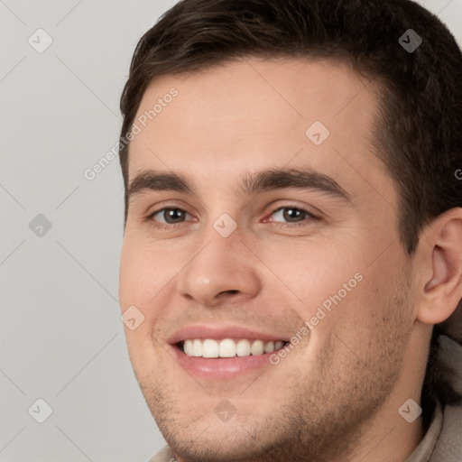 Joyful white young-adult male with short  brown hair and brown eyes