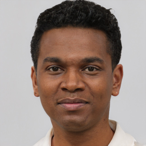 Joyful black young-adult male with short  black hair and brown eyes