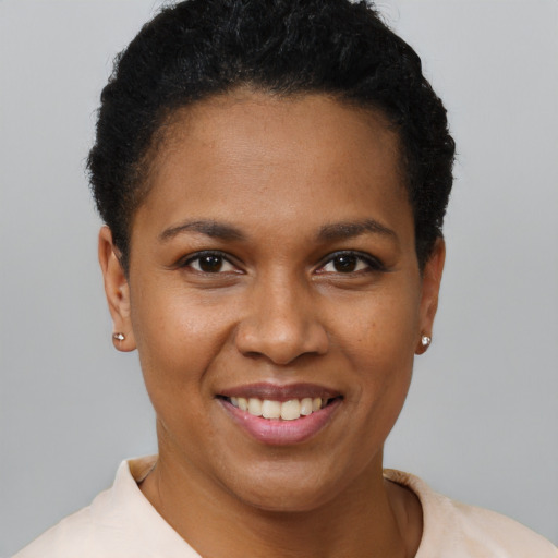 Joyful black young-adult female with short  black hair and brown eyes