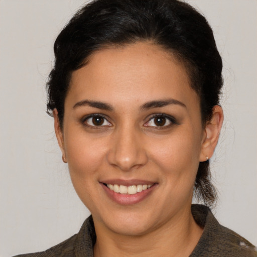 Joyful latino young-adult female with medium  brown hair and brown eyes