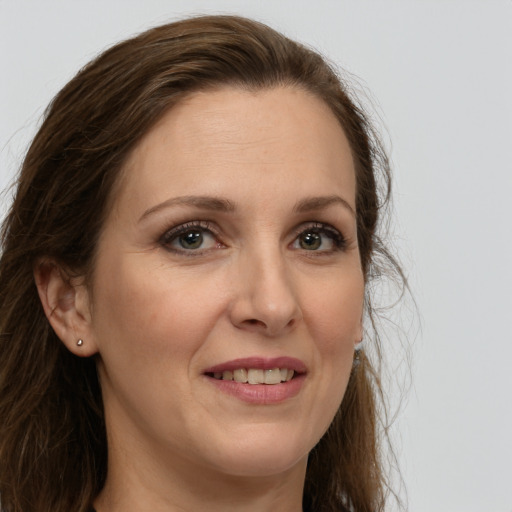 Joyful white adult female with long  brown hair and brown eyes