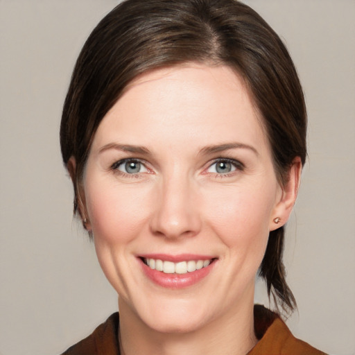 Joyful white young-adult female with medium  brown hair and grey eyes