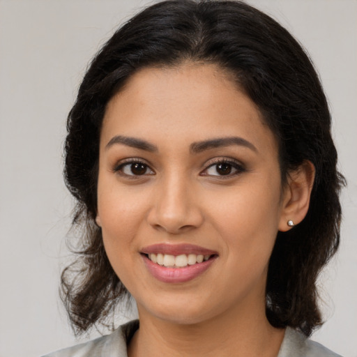 Joyful latino young-adult female with medium  brown hair and brown eyes