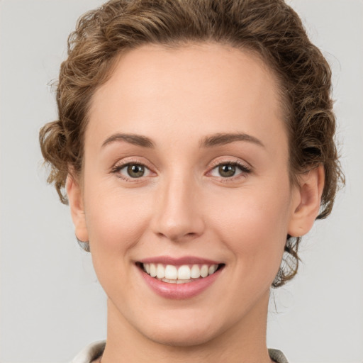 Joyful white young-adult female with short  brown hair and green eyes