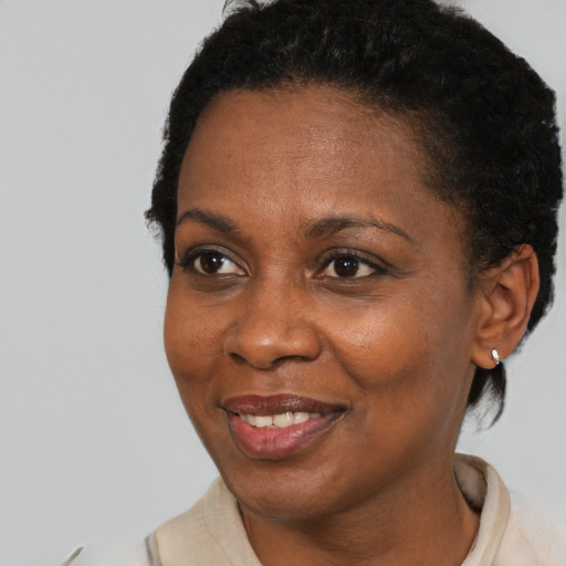 Joyful black adult female with short  black hair and brown eyes