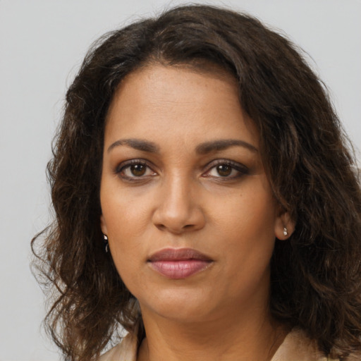 Joyful black young-adult female with long  brown hair and brown eyes