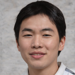 Joyful asian young-adult male with short  brown hair and brown eyes