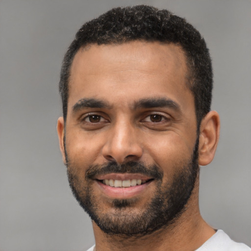 Joyful black young-adult male with short  black hair and brown eyes