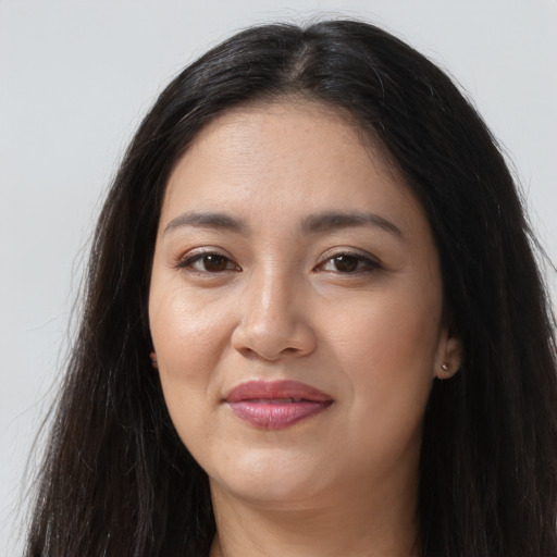 Joyful latino young-adult female with long  brown hair and brown eyes
