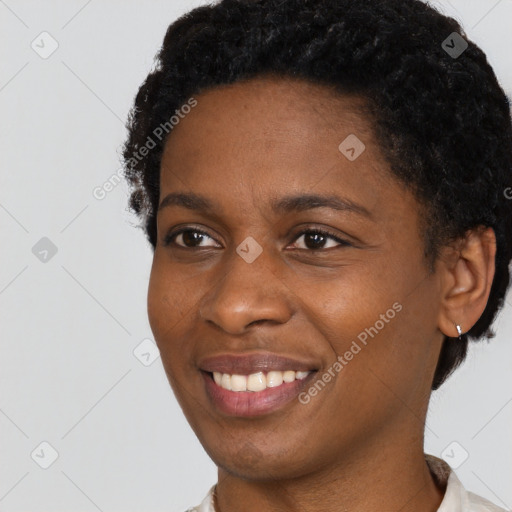 Joyful black young-adult female with short  black hair and brown eyes