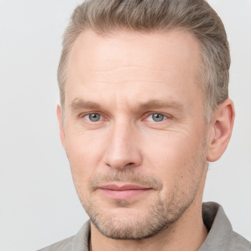 Joyful white adult male with short  brown hair and grey eyes