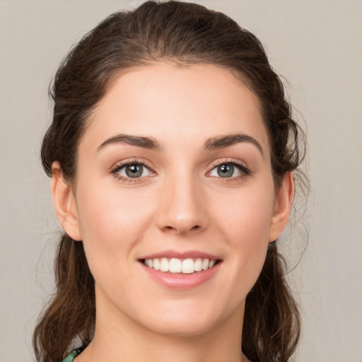 Joyful white young-adult female with medium  brown hair and green eyes