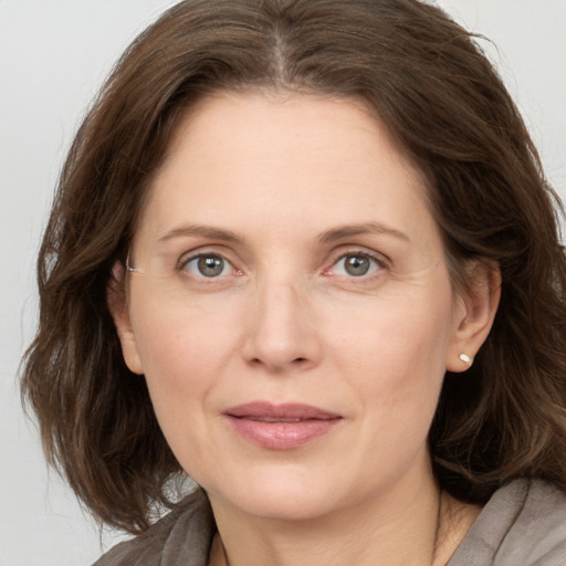 Joyful white adult female with medium  brown hair and grey eyes