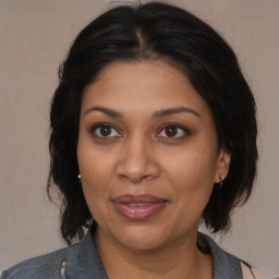 Joyful black adult female with medium  brown hair and brown eyes