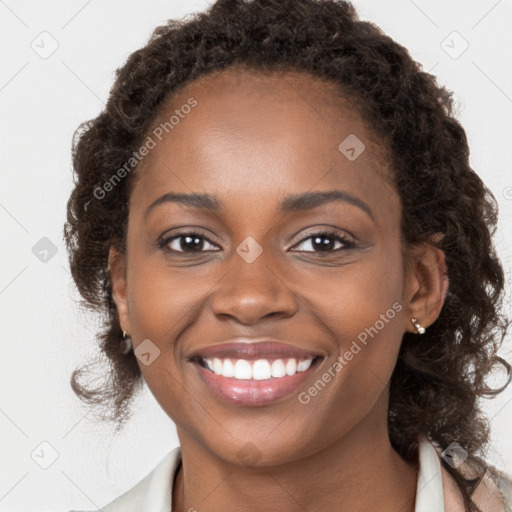 Joyful black young-adult female with long  brown hair and brown eyes