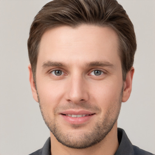 Joyful white young-adult male with short  brown hair and grey eyes