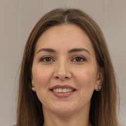 Joyful white young-adult female with long  brown hair and brown eyes