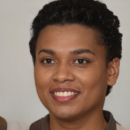 Joyful black young-adult female with short  brown hair and brown eyes