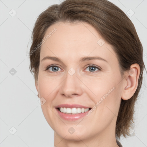 Joyful white young-adult female with medium  brown hair and grey eyes