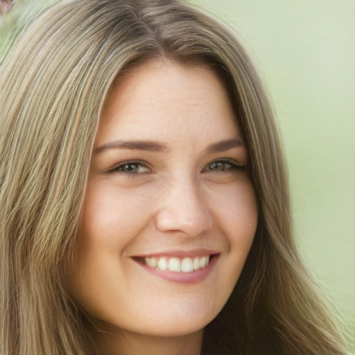 Joyful white young-adult female with long  brown hair and green eyes