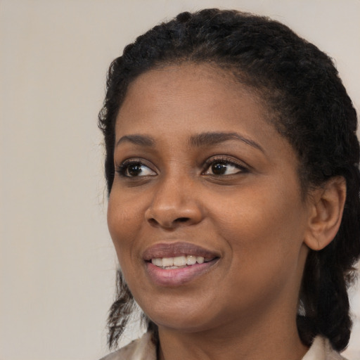 Joyful black young-adult female with medium  brown hair and brown eyes