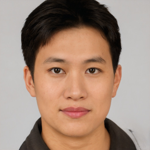 Joyful asian young-adult male with short  brown hair and brown eyes