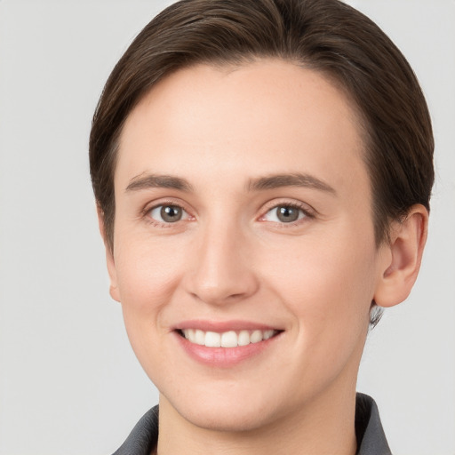 Joyful white young-adult female with short  brown hair and grey eyes