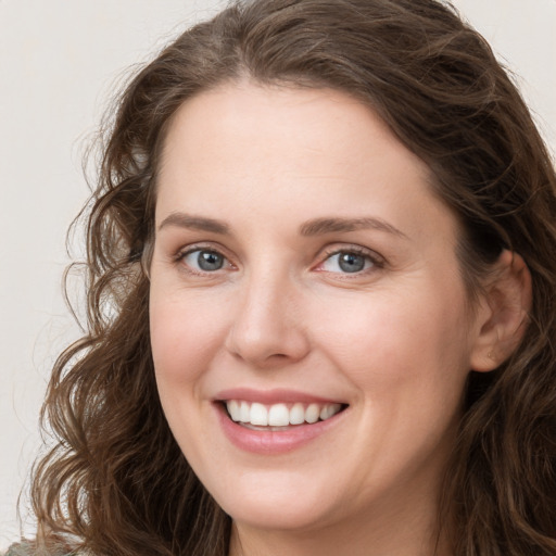 Joyful white young-adult female with long  brown hair and green eyes