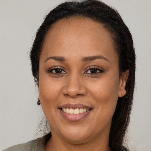 Joyful latino adult female with long  brown hair and brown eyes