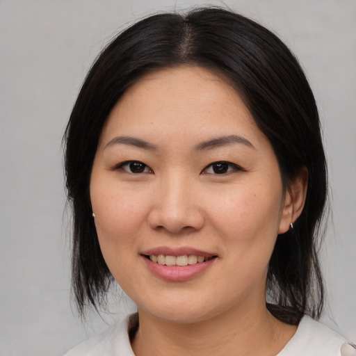 Joyful asian young-adult female with medium  black hair and brown eyes