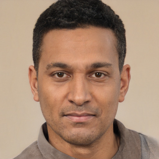 Joyful latino adult male with short  black hair and brown eyes