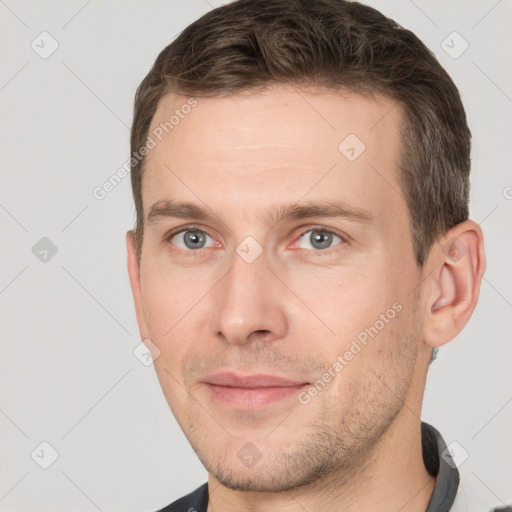 Joyful white young-adult male with short  brown hair and grey eyes