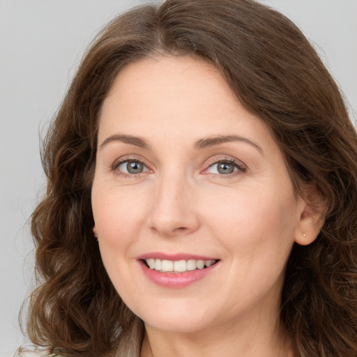 Joyful white young-adult female with long  brown hair and green eyes