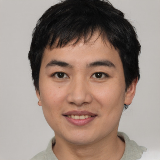 Joyful asian young-adult male with short  black hair and brown eyes