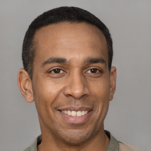 Joyful latino adult male with short  brown hair and brown eyes
