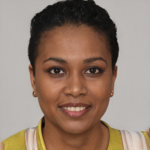 Joyful black young-adult female with short  brown hair and brown eyes