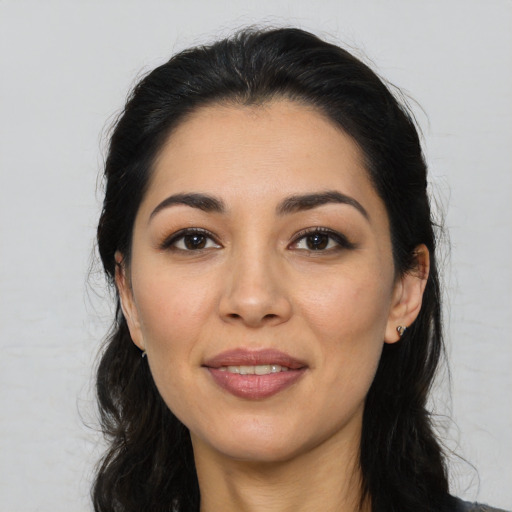 Joyful latino young-adult female with long  black hair and brown eyes