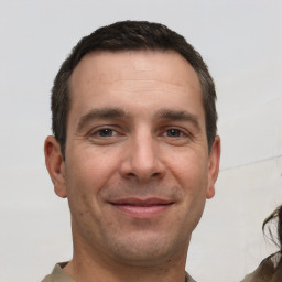 Joyful white adult male with short  brown hair and brown eyes