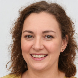 Joyful white adult female with long  brown hair and brown eyes