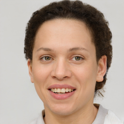 Joyful white young-adult female with short  brown hair and green eyes