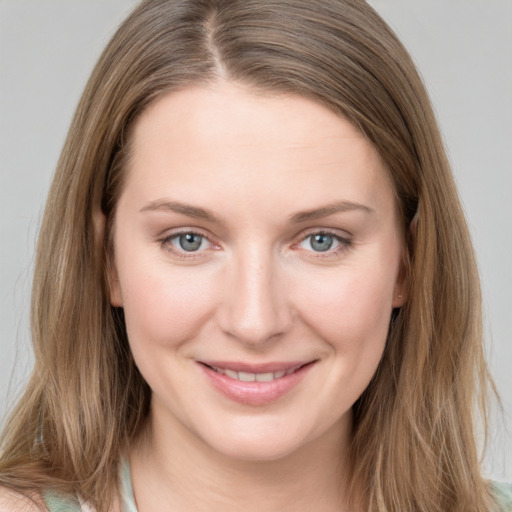 Joyful white young-adult female with long  brown hair and grey eyes